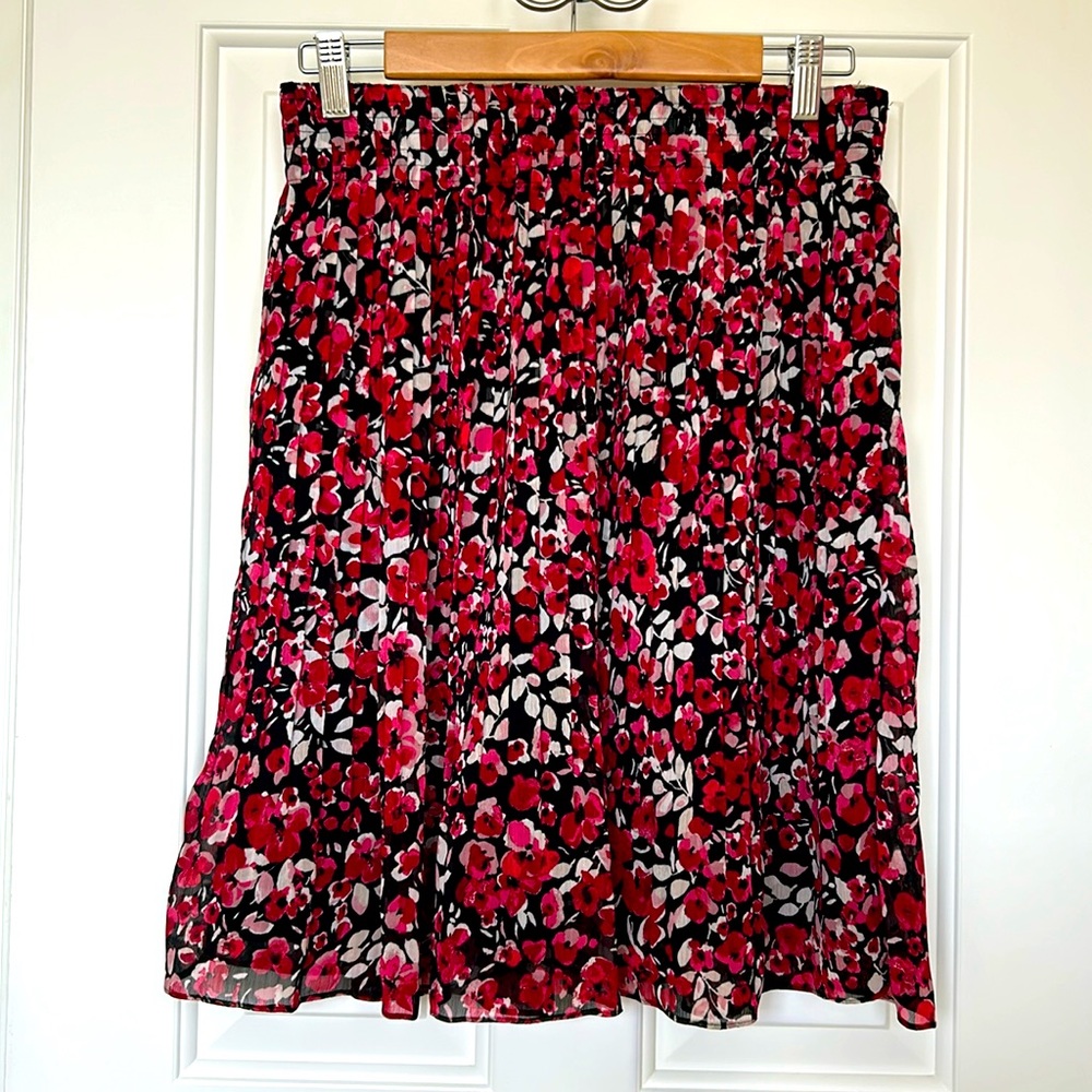 WHBM pleated skirt with red and cream floral design on black. Size XS.